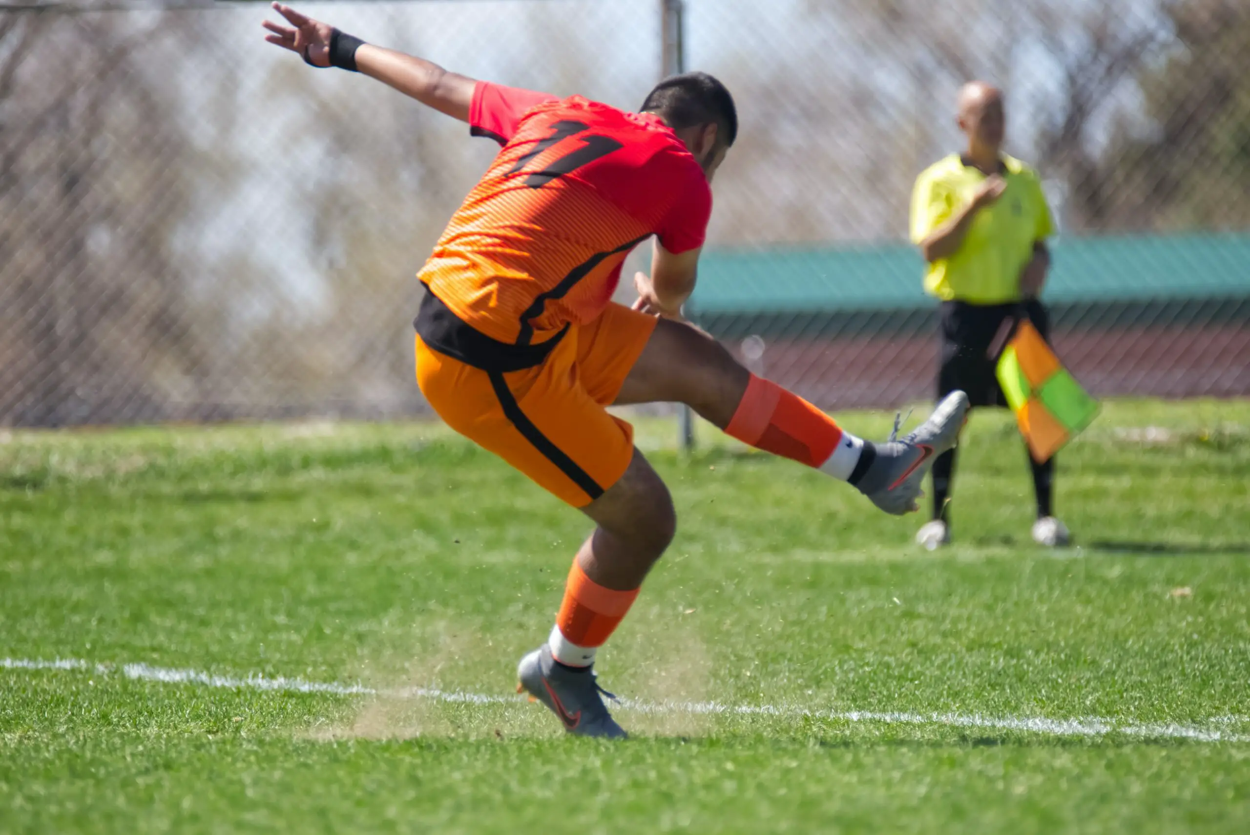 A footballer kicking a football hard